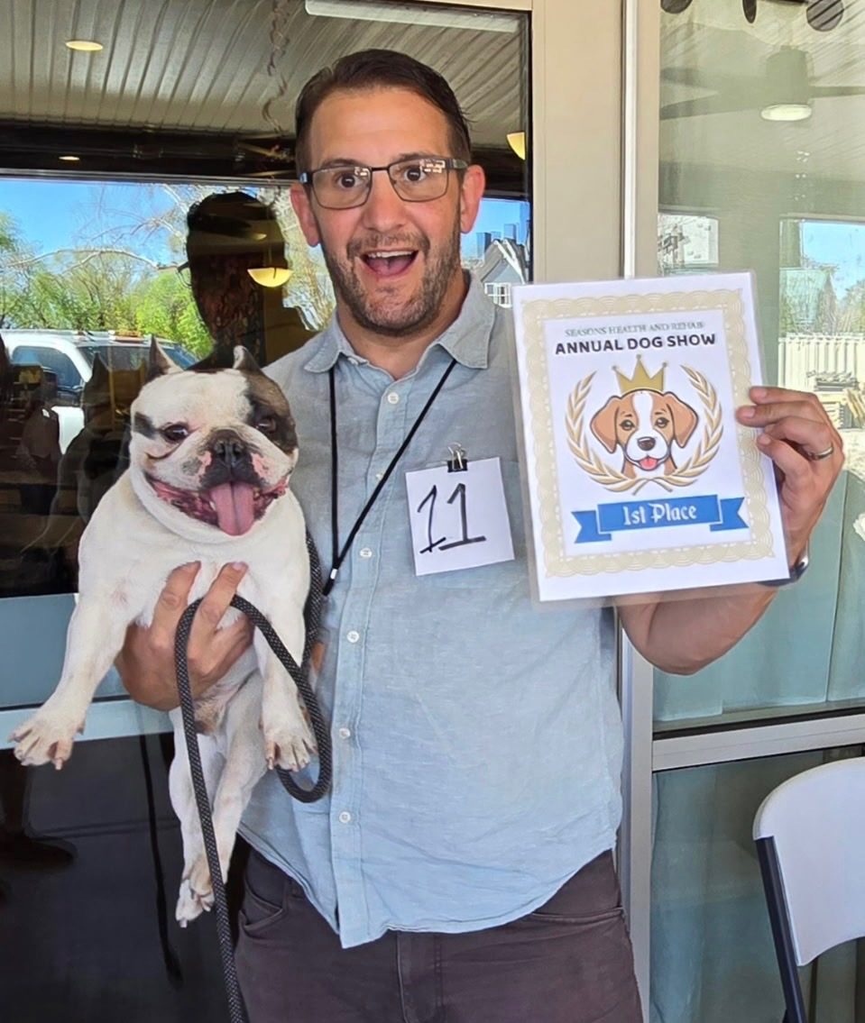 A Southern Utah Hospice team member holding a first place certificate at a local annual dog show