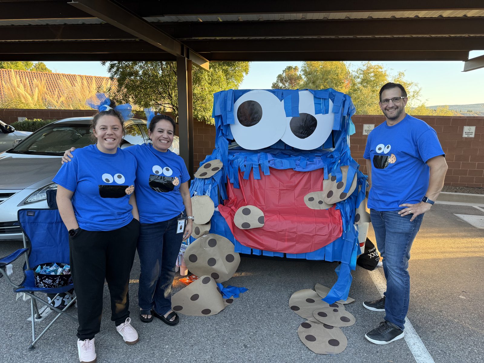 Four members of the Southern Utah Hospice team in matching shirts at a community trunk-or-treat event